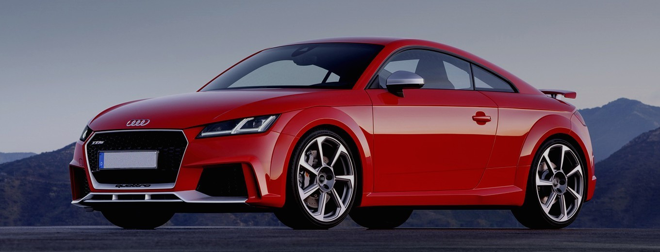 Ljubko belo-črni športni avto Audi TT RS v rdeči barvi, prikazan spredaj ob strani na odprtem asfaltu z gorskim ozadjem.