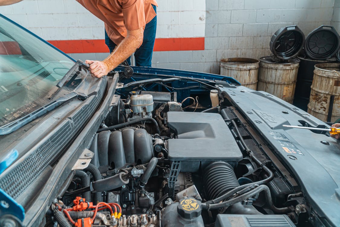 Close-up of a car engine bay showing engine components and tools, illustrating an engine service or carbon-cleaning procedure